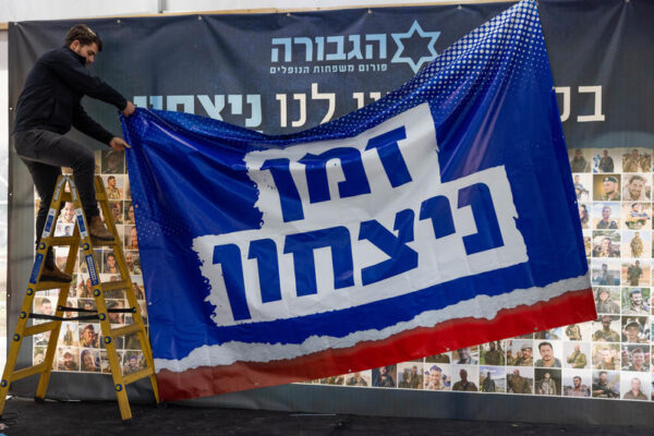 פעילי פורום גבורה תולים שלט לפני מסיבת עיתונאים, ינואר 2025 (צילום ארכיון: חיים גולדברג/פלאש90)