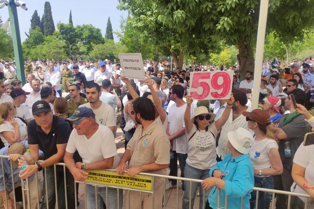 שלט מחאה להשבת החטופים בטקס יום הזיכרון בקריית שאול (צילום: ניצן צבי כהן)