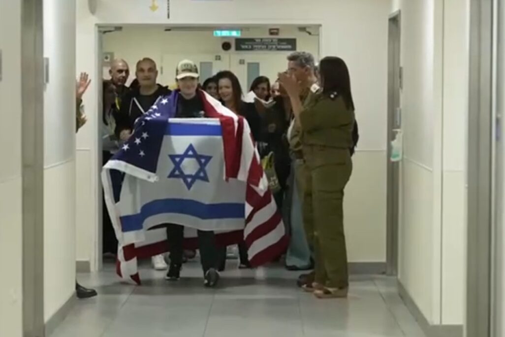 עידן אלכסנדר בבית החולים איכילוב, אוחז בדגלי ישראל וארה"ב (צילום: דובר צה"ל)