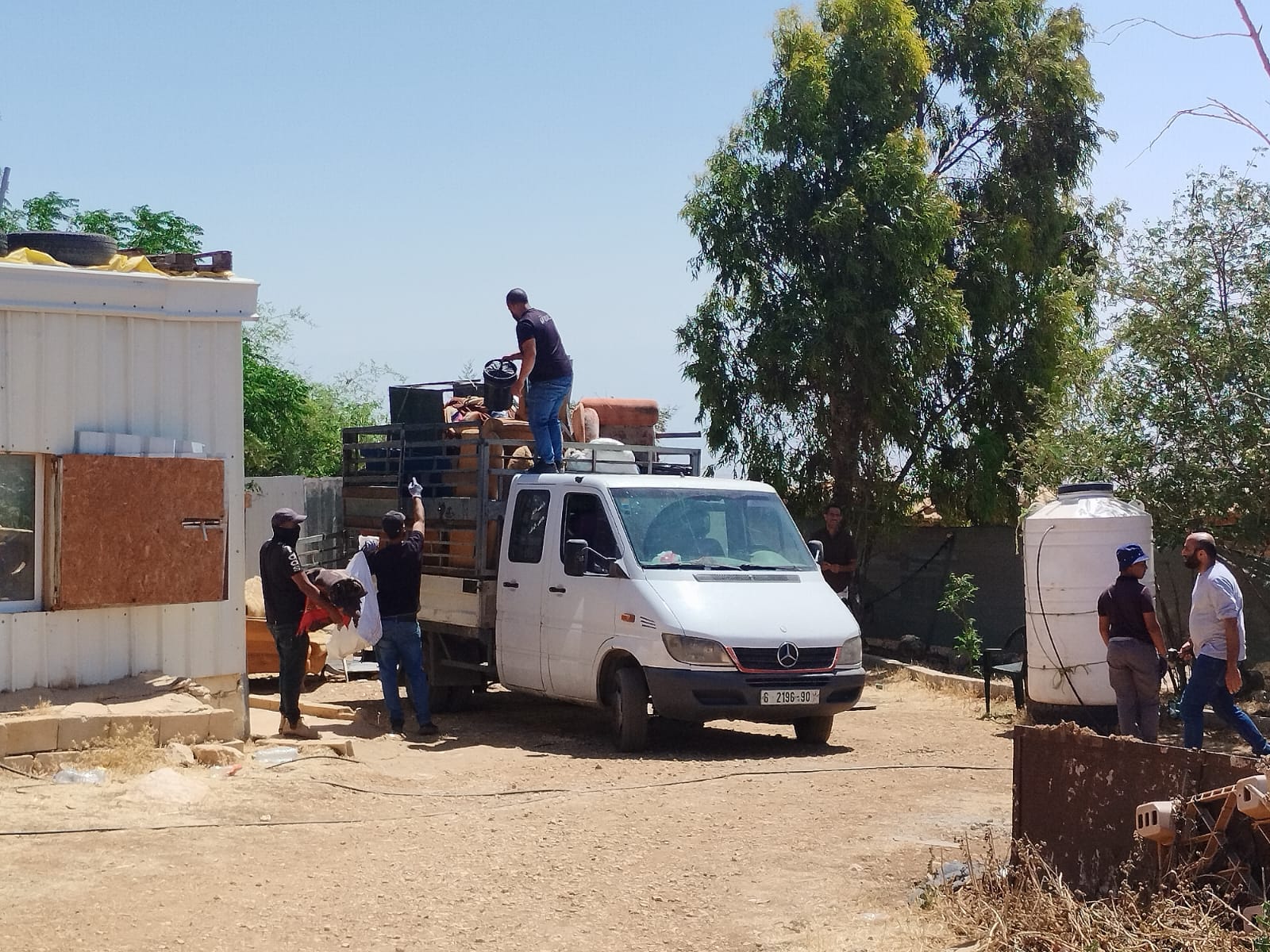 תושבים בכפר מעמיסים ציוד (צילום: יניב שרון)