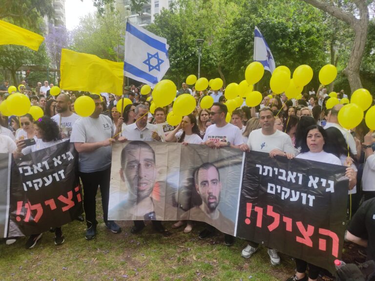 הצועדים נושאים שלט עם תמונותיהם של גיא גלבוע דלאל ואביתר דוד מהשבי, מתוך סרטון שחמאס פרסם (צילום: ניצן צבי כהן)