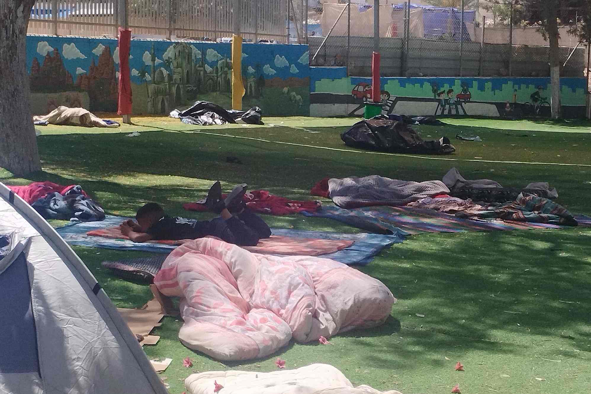 ילד משחק בטלפון במתחם הלינה הזמני בחצר בית הספר. "יש כאן לפחות 100 ילדים כמוהו" (צילום: יניב שרון)