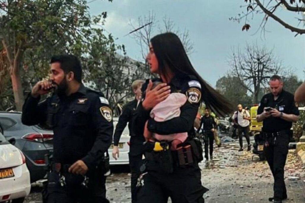 השוטרת אביב סרגה מחלצת פעוטה מבין ההריסות בפגיעה הישירה במרכז (צילום: המשטרה)