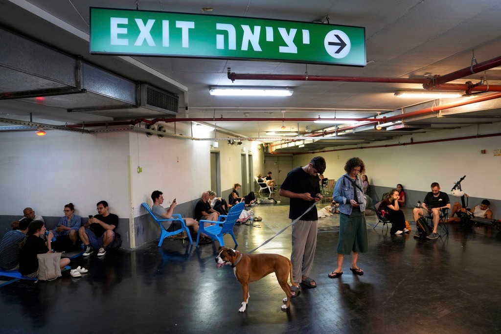 אנשים מתגוננים בזמן האזעקות בתל אביב (צילום: AP Photo/Baz Ratner) אנשים מתגוננים בזמן האזעקות בתל אביב (צילום: AP Photo/Baz Ratner)
