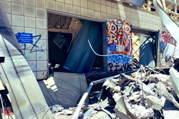 הבניין שספג את הפגיעה הישירה בחיפה והגרפיטי לזכרה של הימן ז"ל (צילום: יהל פרג')
