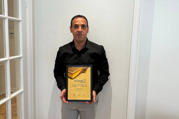 אלי שרעבי והפרס (צילום: התאחדות בעלי הוצאות הספרים)