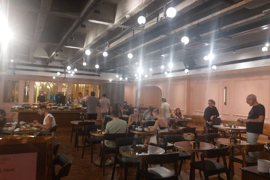 מפונים נאספים במלון בובו. שיחות חולין לאחר פגיעת הטיל בבניין רב-הקומות בתל אביב (צילום: מיכל מרנץ) מפונים נאספים במלון בתל אביב במהלך המלחמה עם איראן (צילום: מיכל מרנץ)
