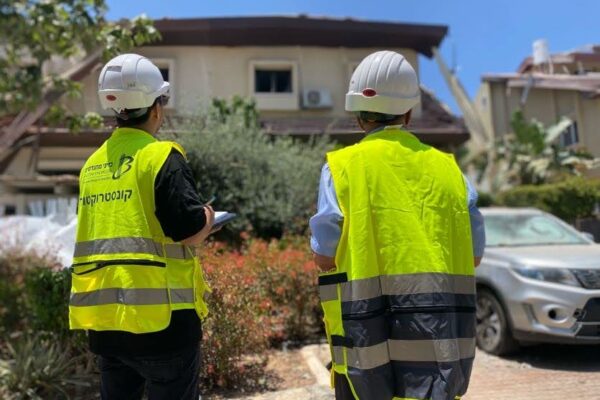 עובד עיריית ראשון לציון מחוץ לבניין שנפגע מטיל איראני (צילום: יהל פרג')