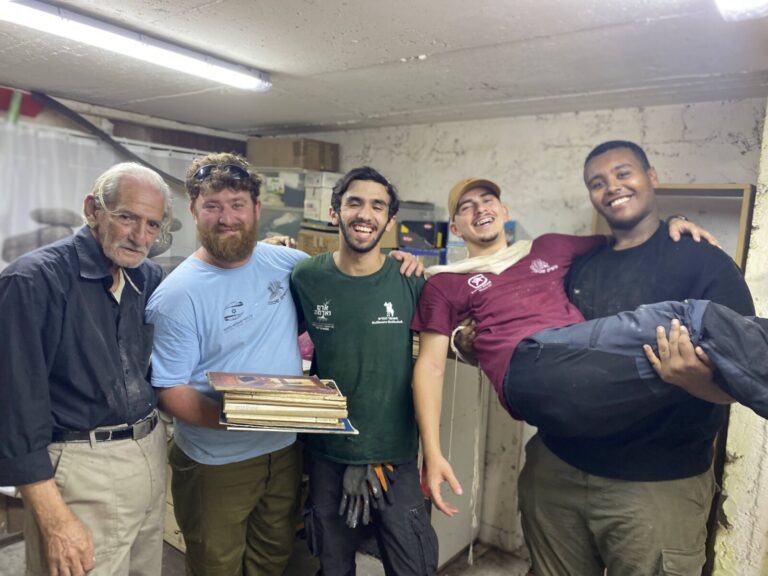 בנימין חחיאשוילי (שני משמאל) עם ספרי הקודש, לצד מתנדבים נוספים של 'עושים שכונה' (צילום: יהל פרג')