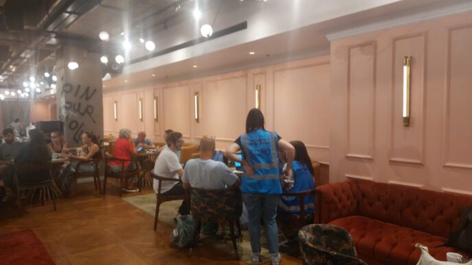 מתנדבי עיריית תל אביב פועלים במלון בובו, בו שוהים מפוני המגדל התל אביבי שספג פגיעה ישירה (צילום: מיכל מרנץ)