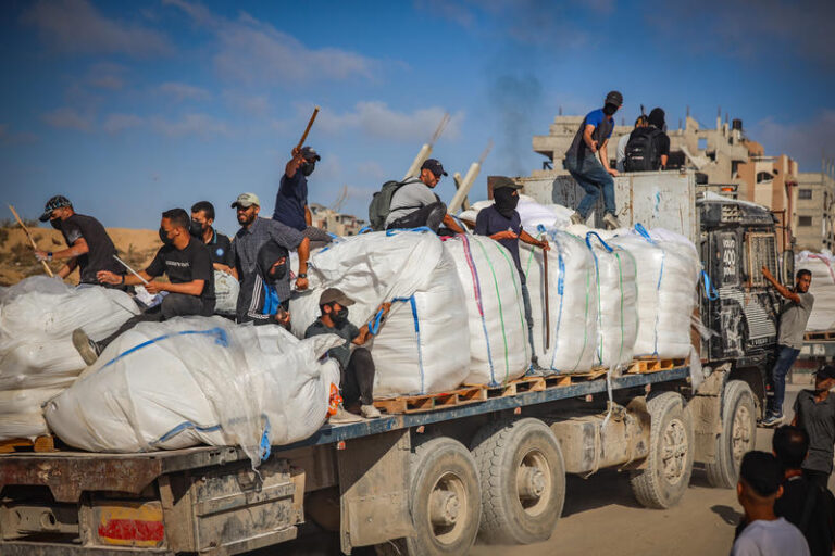 חמושים פלסטינים על משאיות סיוע ליד מעבר זיקים שבין ישראל לצפון הרצועה (צילום: Ali Qariqa/Flash90)