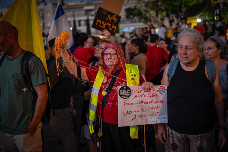 מפגינה עם שלט הקורא לשלום בעברית, אנגלית וערבית (צילום: אריק מרמר/פלאש90)