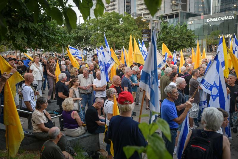 טייסים לשעבר וטייסי מילואים של חיל האוויר, יחד עם מפגינים נוספים, משתתפים במחאה נגד המשך המלחמה ולמען שחרור החטופים סמוך לבסיס הקריה בת"א, אוגוסט 2025 (צילום: אבשלום ששוני/Flash90)