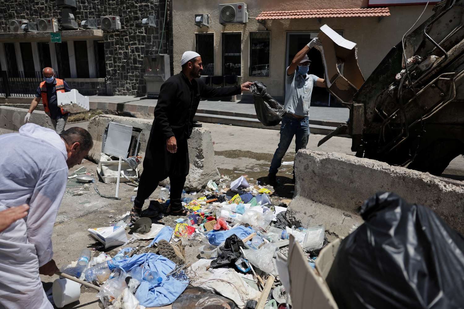 אזרחים מפנים זבל ברחובות א-סווידא (צילום: REUTERS/Khalil Ashawi) אזרחים מפנים זבל ברחובות א-סווידא (צילום: REUTERS/Khalil Ashawi)