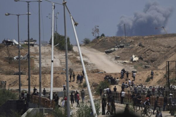 טנקים צה"ליים ועשן מיתמר נראים ממרכז החלוקה של GHF ברפיח, 29 במאי 2025. "האזרחים נדרשים להיכנס לאזורי מלחמה" (צילום: AP Photo/Abdel Kareem Hana)