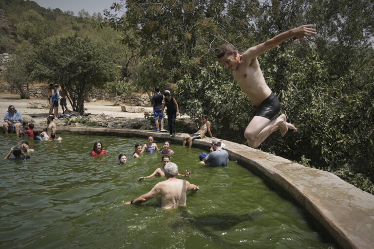צעיר קופץ למים במעיין עין לבן ליד ירושלים, 13 באוגוסט 2023 (צילום: AP Photo/Mahmoud Illean)