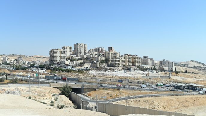 הכפר א-זעיים מזרחית לירושלים. מימין: מחסום א-זעיים דרכו נוסעים ממעלה אדומים לירושלים. למטה: כביש 'מרקם חיים' (צילום: אור גואטה)