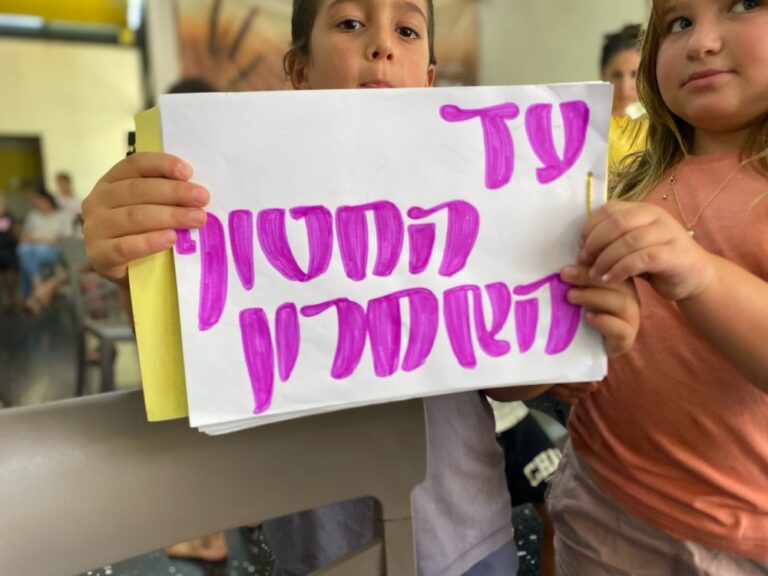 ילדי קיבוץ עלומים עם ציור שהכינו לאימו ואחותו של החטוף ביפין ג'ושי (צילום: יהל פרג')
