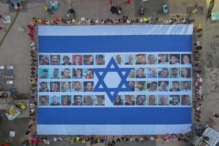 דגל ישראל עם תמונות החטופים והחטופה נפרש בכיכר החטופים בתל אביב בשעה 06:29 (צילום: יאיר פלטי)