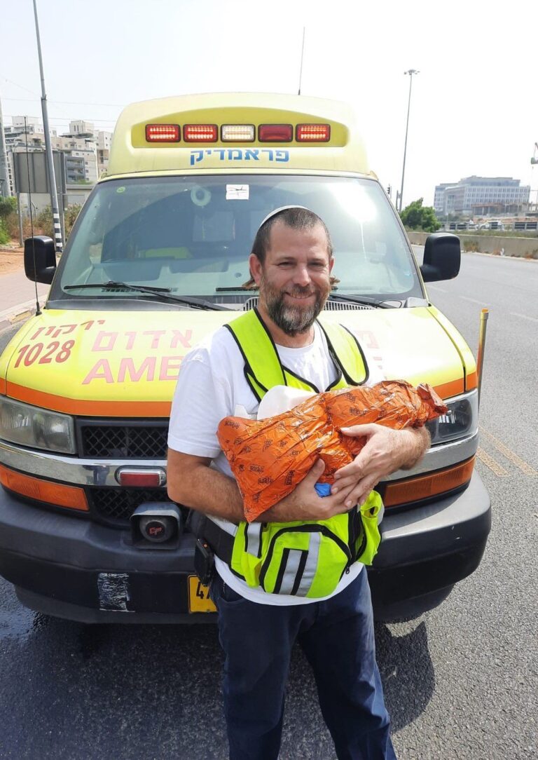 איש צוות מד"א עם תינוק שנולד מחוץ לבית החולים (צילום: תיעוד מבצעי מד"א)