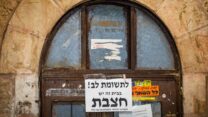 שלט אזהרה מפני מחלת החצבת על דלת בשכונת מאה שערים בירושלים, 31 ביולי 2025 (צילום: חיים גולדברג/פלאש 90)