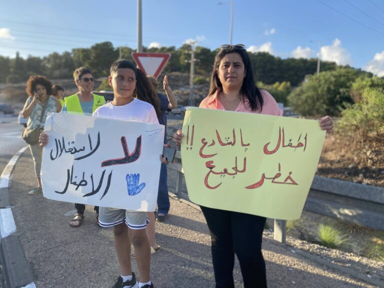 עו"ס אחלאם מארון ובנה בהפגנה נגד ניצול הילדים שבצד הכביש (צילום: יהל פרג')