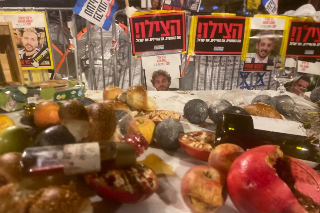 מיצג השולחן השבור, ברקע הפוסטר של אלון אהל החטוף בעזה (צילום: יהל פרג')
