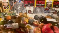 מיצג השולחן השבור, ברקע הפוסטר של אלון אהל החטוף בעזה (צילום: יהל פרג')