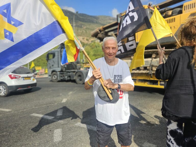 עמוס מלהבות הבשן. עומד בכל ערב עם דגלים בצומת הגומא (צילום: מאיה רונן)