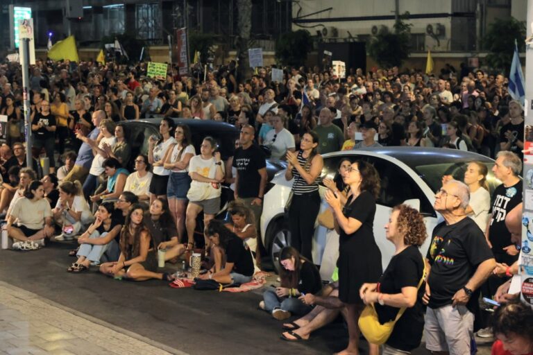 מוחים במסך המקרין את עצרת המחאה, סמוך לכיכר החטופים (צילום: דורון הבסי)