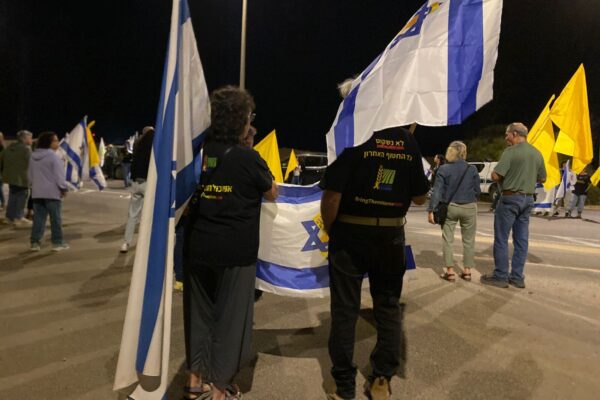 תושבי אשכול מחכים לחללים החטופים עם דגלי ישראל (צילום: יהל פרג')