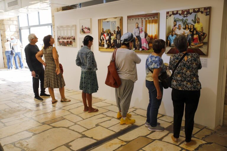 מבקרים צופים בתערוכה בבית השומר (צילום: רועי כשר)