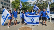 חניכי וחניכות תנועת הנוער העובד והלומד צופים בהגעת החטופים ששוחררו לבית החולים בילינסון בפתח תקווה (צילום: מאיה רונן)
