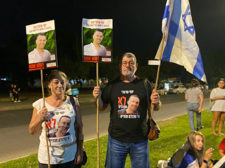 איריס ודורון עם שלט הנושא את תמונתו של החלל החטוף יוסי שרעבי ז"ל, עם שובו של ארונו מרצועת עזה (צילום: יהל פרג')