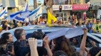 ויקי כהן ברכב שהשיב את בנה נמרוד כהן, מוקף בתושבי רחובות (צילום: אסף צבי)