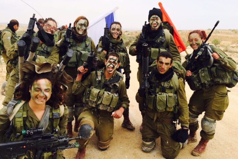 ענבר הימן (למטה משמאל) במסע בטירונות, עם רובה קלעים ואלונקה על הגב. "היא צרחה על כל מי שהציע לה עזרה שהיא מסיימת את המסלול עם האלונקה" (צילום: אלבום פרטי)
