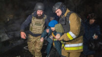 כוחות חילוץ מפנים אישה מבוגרת מבניין מגורים שנפגע במתקפת טילים רוסית באוקראינה (צילום: AP/Andrii Marienko)