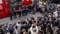 מזכיר הביטחון של הונג קונג כריס טנג (השלישי משמאל בשורה האחורית) מוסר הצהרה לאחר השריפות הקטלניות במתחם וואנג פוק קורט, טאי פו (צילום: AP Photo/Chan Long Hei)