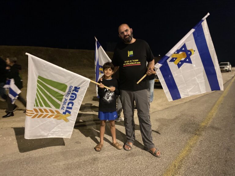 אייל בן עזר ובנו יער בצומת גמה. "השנייה שנהיה שקט כשהשיירה מגיעה, זה מצמרר" (צילום: יהל פרג')