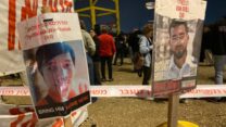 שלטי מחאה בשער הנגב הקוראים להשבת רן גואילי וסותטיסאק רינטלאק לקבורה בישראל (צילום: יהל פרג')