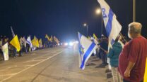 אנשים מקבלים את השיירה בה ארון חלל חטוף בצומת גמה באשכול (צילום: יהל פרג')
