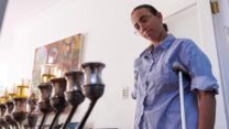 חיה דדון, שהצילה ילדים בטבח בסידני ונפצעה ברגלה, עם חנוכייה (צילום: Reuters/Cordelia Hsu)