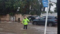 עובד ניקיון באזור במזג האוויר הסוער (צילום: מתוך דף הפייסבוק של המועצה המקומית אזור)