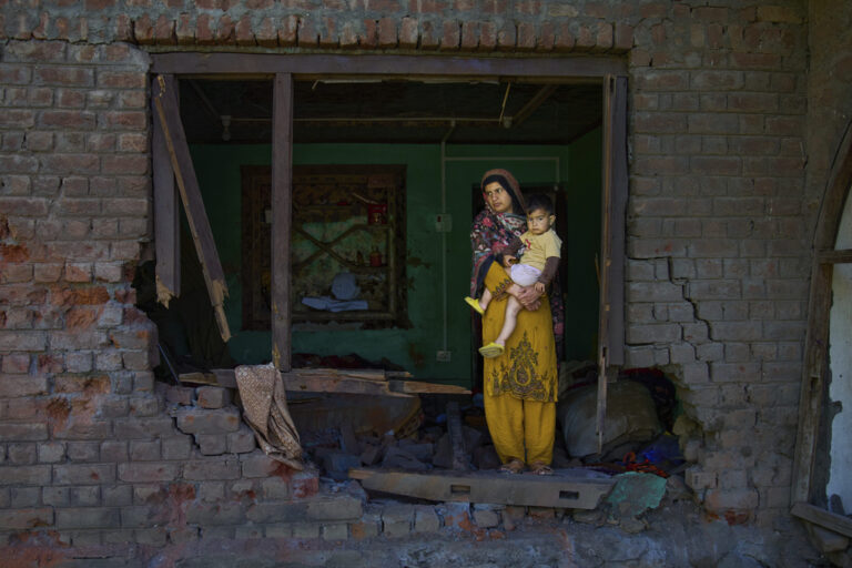 Indian woman holding her child in their home damaged by Pakistani shelling, Indian Kashmir, May 2025 (Photo: AP Photo/Dar Yasin)