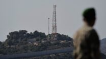 חייל צבא לבנוני מביט על מוצב צה"ל בחניתה מכפר אלמה אל-שעב שבדרום לבנון, נובמבר 2025 (צילום: AP Photo/Bilal Hussein)