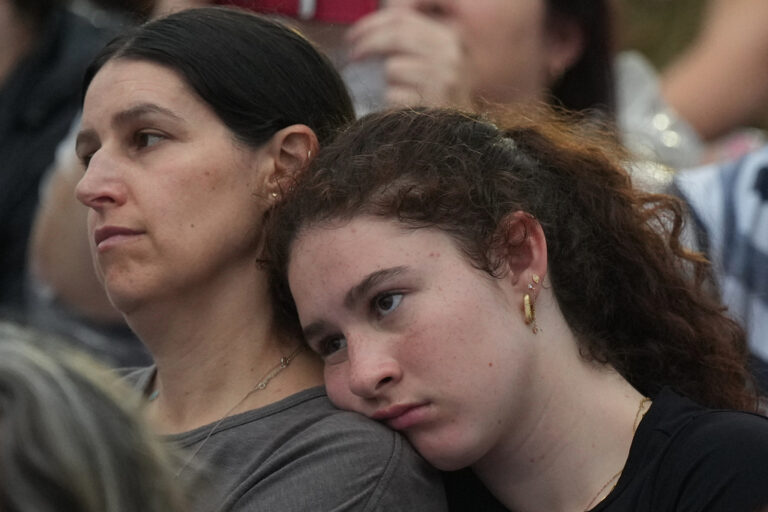 אם ובתה בקהל המתייחדים עם זכר הנרצחים (צילום: AP Photo/Mark Baker)