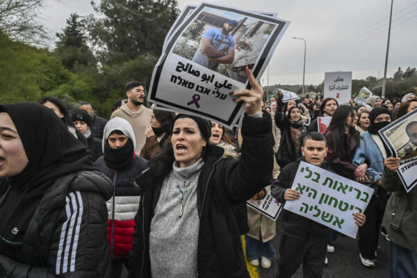 מפגינה נושאת שלט עם תמונתו של עלי אבו סלאח, שנרצח ב-2023, במחאה נגד הפשיעה בסח'נין, 22 בינואר 2026 (צילום: מיכאל גלעדי/פלאש90)