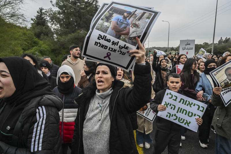 מפגינה נושאת שלט עם תמונתו של עלי אבו סלאח, שנרצח ב-2023, במחאה נגד הפשיעה בסח'נין, 22 בינואר 2026 (צילום: מיכאל גלעדי/פלאש90)