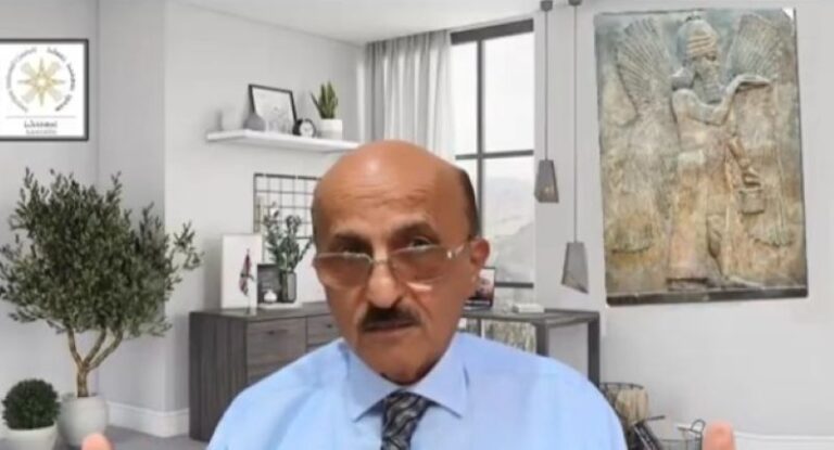 הרמיז שאהן עם הדגל והדגם ברקע (צילום מסך: מתוך הריאיון בזום)