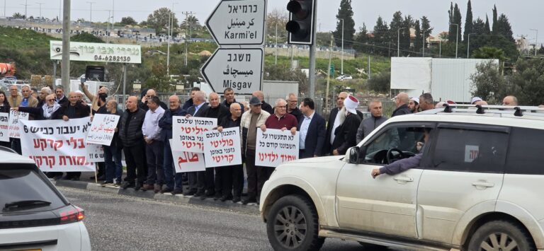 מפגינים בשפרעם נושאים שלטים: "לא תתעשרו על חשבוננו"; "התכנון שלכם פוליטי, גזעני באופן קריטי" (צילום: פרג' חניפ'ס)